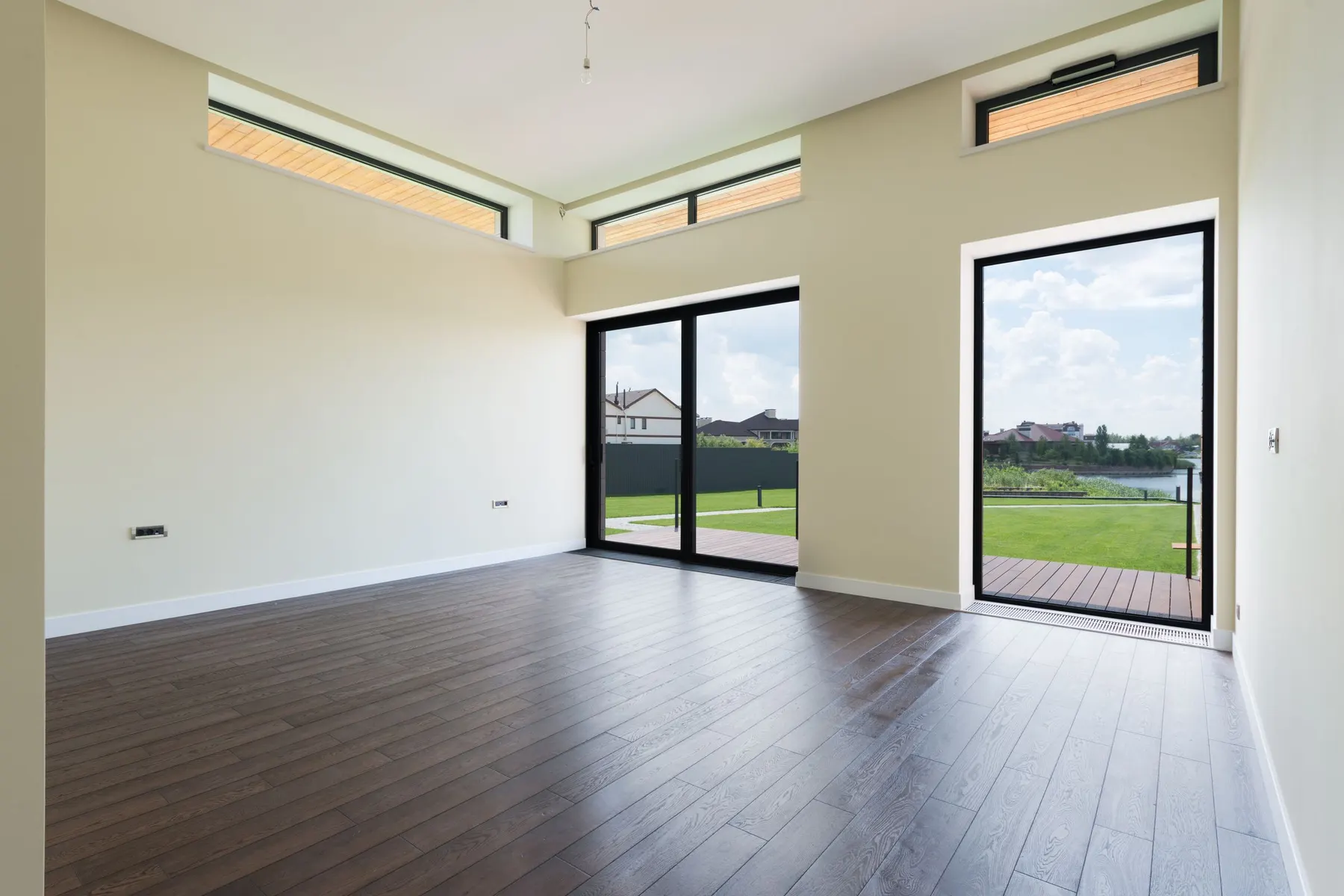 Estancia con un gran fijo, una puerta acristalada de suelo a techo y montantes horizontales en la parte alta. Combinar fijos y hojas practicables es la forma más económica de conseguir mucho vidrio con buen aislamiento.
