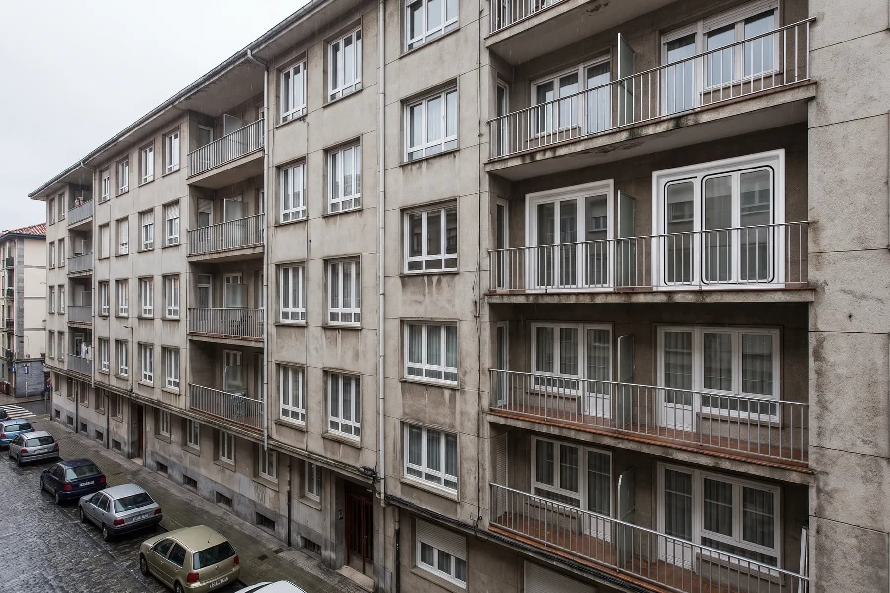 Fachada de bloque con las carpinterías de terraza iguales planta tras planta. Mantener el color y el despiece del resto del edificio es lo que evita discusiones con la comunidad.