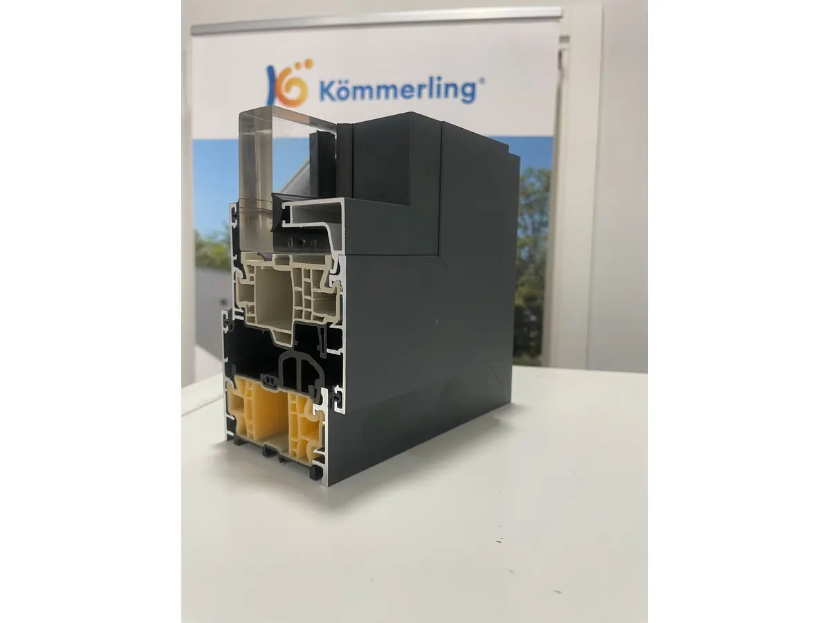 Sección del perfil AluNext AD: núcleo de PVC con cámaras y cara exterior de aluminio lacado. El aluminio es la piel que da la cara al salitre; el aislamiento lo pone el PVC.